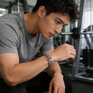 Polished stainless steel anchor link bracelet shown on male wrist in fitness setting