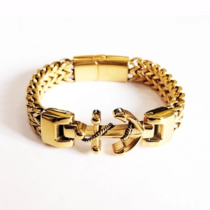 Detail of gold anchor bracelet with woven chain and polished square clasp closure