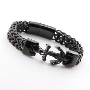 Macro detail of men's black stainless steel anchor bracelet with wheat chain texture