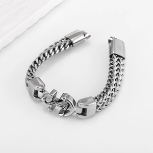 Macro detail of men's stainless steel anchor bracelet with thick woven link chain