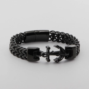 Detail of matte black stainless steel anchor clasp on a woven wheat chain bracelet