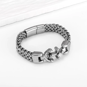 Macro detail of men's stainless steel anchor bracelet with double wheat chain texture