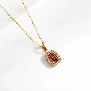 Détail du collier doré avec pierre rectangulaire rouge et halo de zircons fins