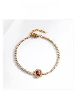Détail d'un bracelet de tennis doré avec pierre rouge rectangulaire et zircons
