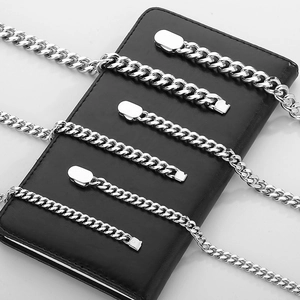Macro shot of silver Cuban link chains in various thicknesses on black leather texture
