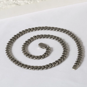 Detailed close-up of dark silver heavy Cuban link chain with high-gloss industrial finish