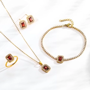Parure de bijoux quatre pièces en or avec zircons rectangulaires rouges sur fond blanc