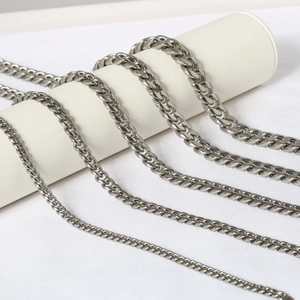 Macro shot of silver Cuban link chain with polished stainless steel flat rings on white stand
