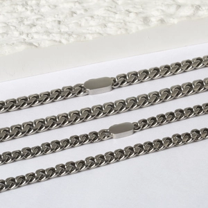Detailed close-up of polished silver Cuban link chain with flat oval engraving plates