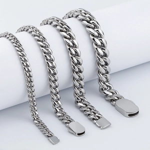 Polished silver cuban link chains in four varied widths on white display props