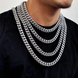 Polished stainless steel Cuban link chains in four lengths shown on a male model