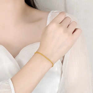 Detailed view of a delicate shimmering star-dotted gold chain bracelet on wrist