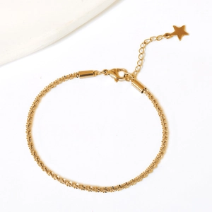 Detailed close-up of gold star pendant extension and textured cauliflower chain bracelet