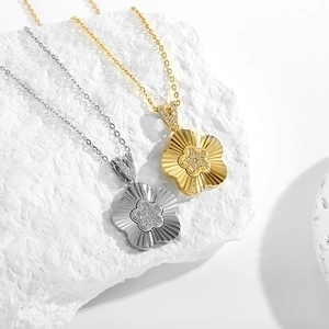 Détails macro des pendentifs fleur en or et argent avec centres en zircons scintillants