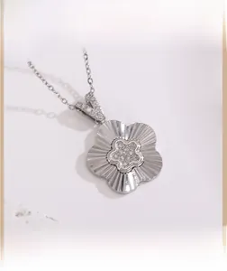 Vue macro du pendentif fleur argenté serti de zircons et sa texture métallique