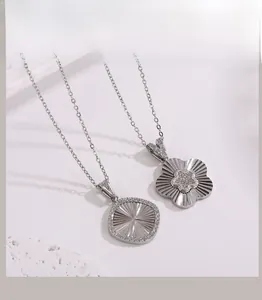 Détail du collier en acier titane avec pendentifs fleur en zircon et motif soleil rayonnant