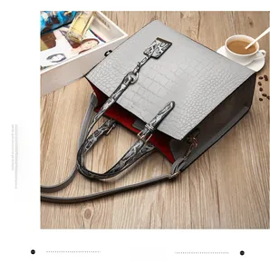 Détail du sac cabas gris motif crocodile avec bandoulière serpent et doublure rouge