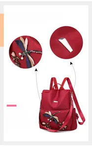 Close-up of colorful dragonfly embroidery and metal buckle on dark red oxford backpack
