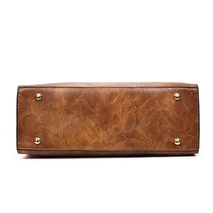 Vue du dessous du sac cabas rétro marron avec pieds métalliques et similicuir