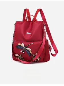 Detail of embroidered dragonfly on red water-resistant oxford fabric backpack