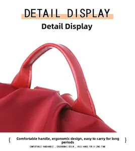 Detail of ergonomic PU leather handle on waterproof nylon travel backpack in red