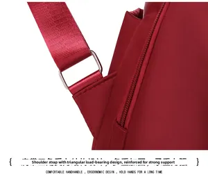 Detail of reinforced triangle stitching and metal adjustment buckle on red oxford backpack