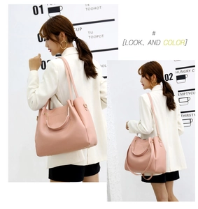 Pink faux leather tote bag detail with sturdy round handles and removable long strap