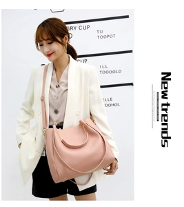 Fashionable pink faux leather crossbody bag with adjustable strap worn by a female model
