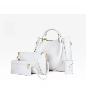Détail d'un ensemble de 4 sacs à main blancs en similicuir avec finitions dorées