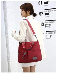Close-up of red nylon tote bag featuring multi-pocket design and gray handles