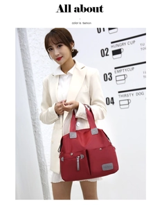 Detailed view of the red nylon tote bag featuring front magnetic pockets and durable handles