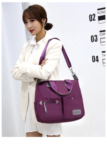Close-up of purple nylon handbag with multiple pockets and adjustable shoulder strap