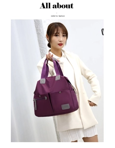 Detail of purple nylon tote bag featuring front utility pockets and sturdy grey handles