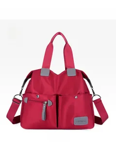 Front detail of red waterproof nylon handbag with multi-pockets and woven handles