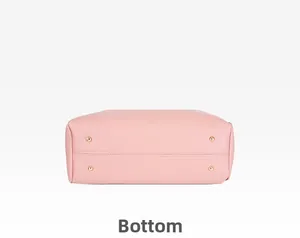Détail du dessous d'un sac rose avec quatre pieds de protection en métal doré brillant