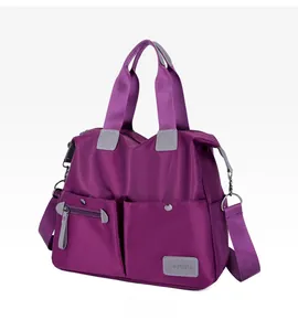 Detail view of purple nylon tote bag showing dual front pockets and durable grey handles