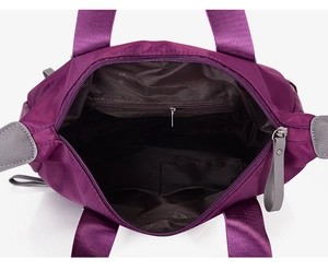 Macro view of purple nylon handbag interior with zip pocket and open compartments