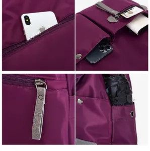 Detail of purple nylon handbag featuring multiple functional zipper pockets and side pockets