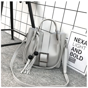Detailaufnahme der grauen Beuteltasche mit Silberschnalle, Quasten und mattem Finish