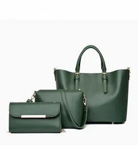 Detailed view of dark green 3-piece bag set including tote, crossbody, and wallet