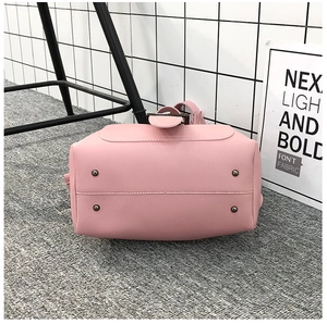Nahaufnahme des rosa Beuteltaschenbodens mit vier Metallschutzstollen und feinen Nähten