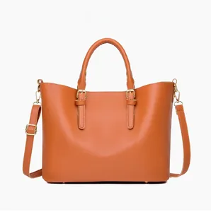 Front view of caramel brown leather tote bag with gold buckles and adjustable shoulder strap
