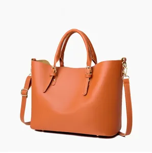 Detail view of orange leather tote bag with gold hardware and adjustable shoulder strap