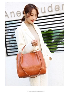 Detailed view of crocodile pattern tote bag in caramel brown with slender straps