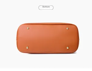 Macro view of orange-brown leather bag bottom with four protective gold metal feet studs