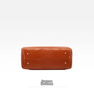 Close-up of brown embossed handbag base with four golden protective metal studs
