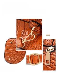 Detail of crocodile embossed leather bag showing gold studs and hardware buckles