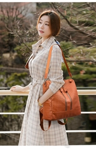 Detail of orange woven leather backpack with double zippers and wide fabric strap