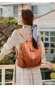 Detail of orange-brown woven texture backpack with vertical zippers and dual straps