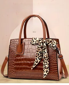 Sac à main marron foncé aspect crocodile avec foulard léopard et bandoulière amovible